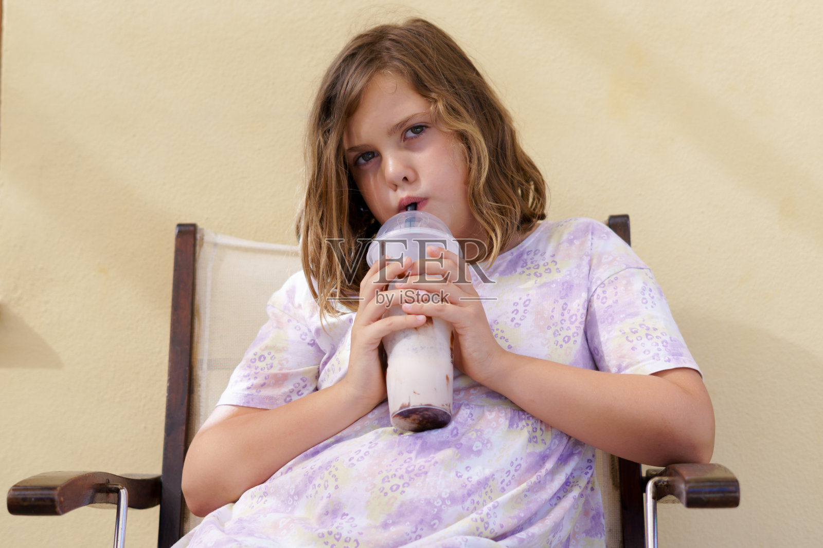 女孩穿着五颜六色的衣服，喝着清爽的水果奶昔照片摄影图片