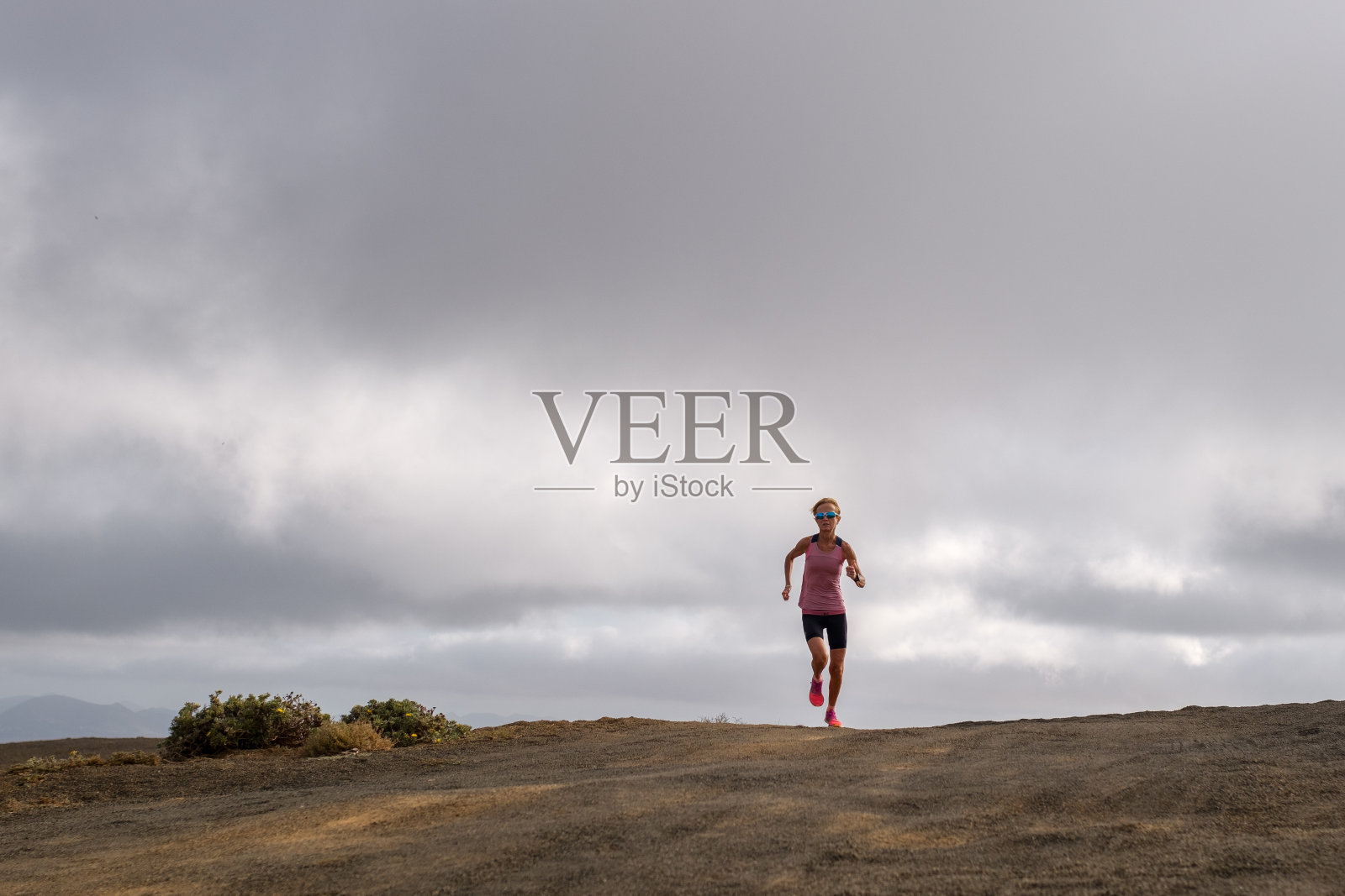 女子在阴天跑到户外健身照片摄影图片