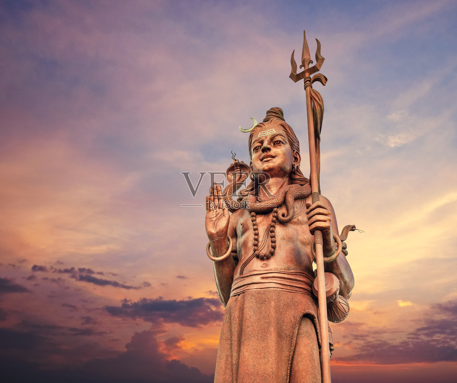 巨大的湿婆雕像Mangal Mahadev是一件33米高的艺术品，位于毛里求斯岛的Ganga talao寺庙，在蓝色的黄昏日落天空中。照片摄影图片