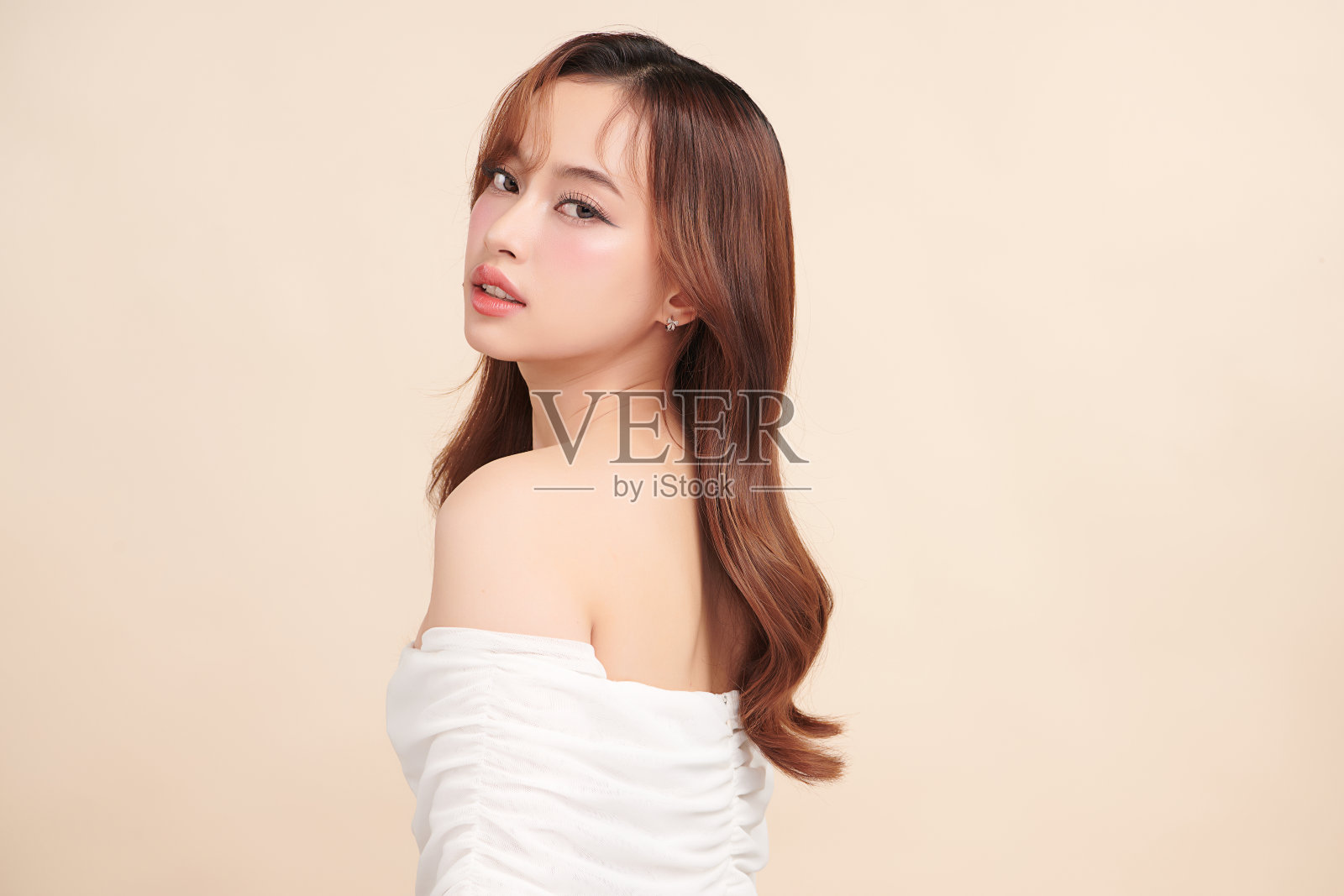 美丽的年轻亚洲女性干净新鲜的皮肤在米色背景，面部护理，面部护理，美容，美容和水疗，亚洲女性肖像。照片摄影图片