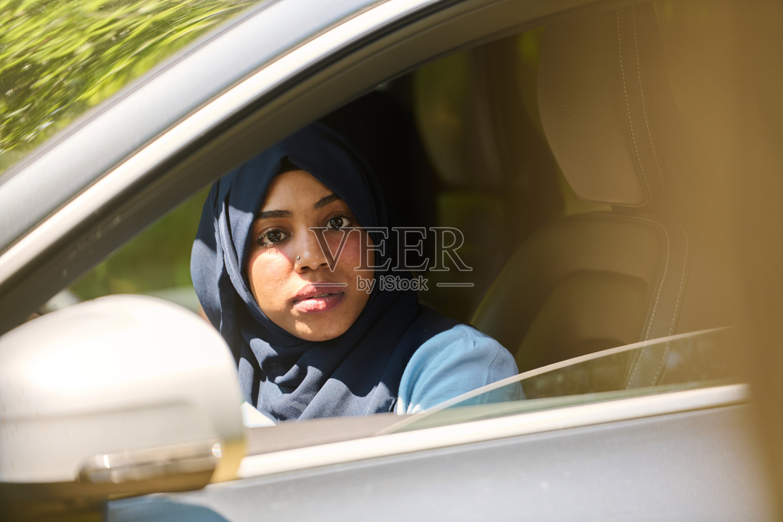 两名戴着头巾的穆斯林妇女在一起乘车穿越沙漠时用智能手机交谈照片摄影图片