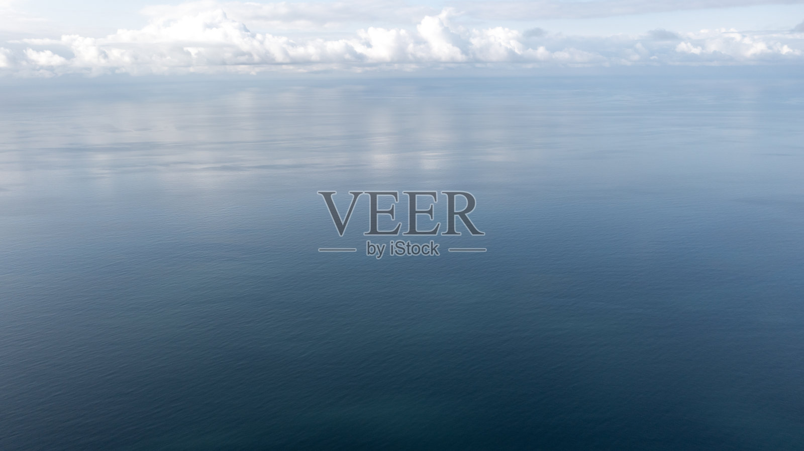 鸟瞰无边无际的大海和多云的天空。照片摄影图片