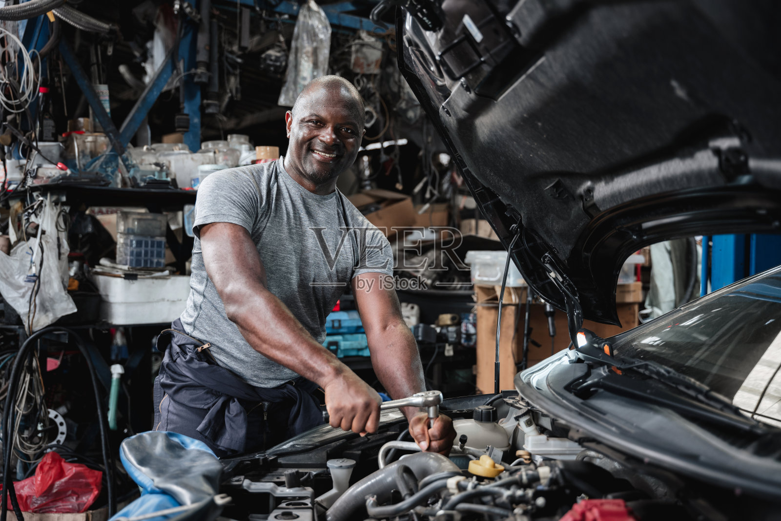 一个男人在修理汽车发动机时面带微笑照片摄影图片