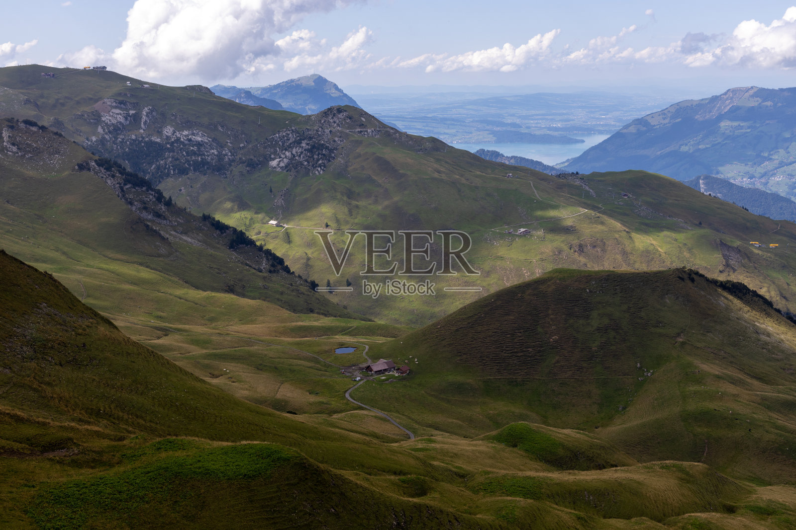 美丽的景色，绿色的山丘，牧场和湖泊与山脉。照片摄影图片