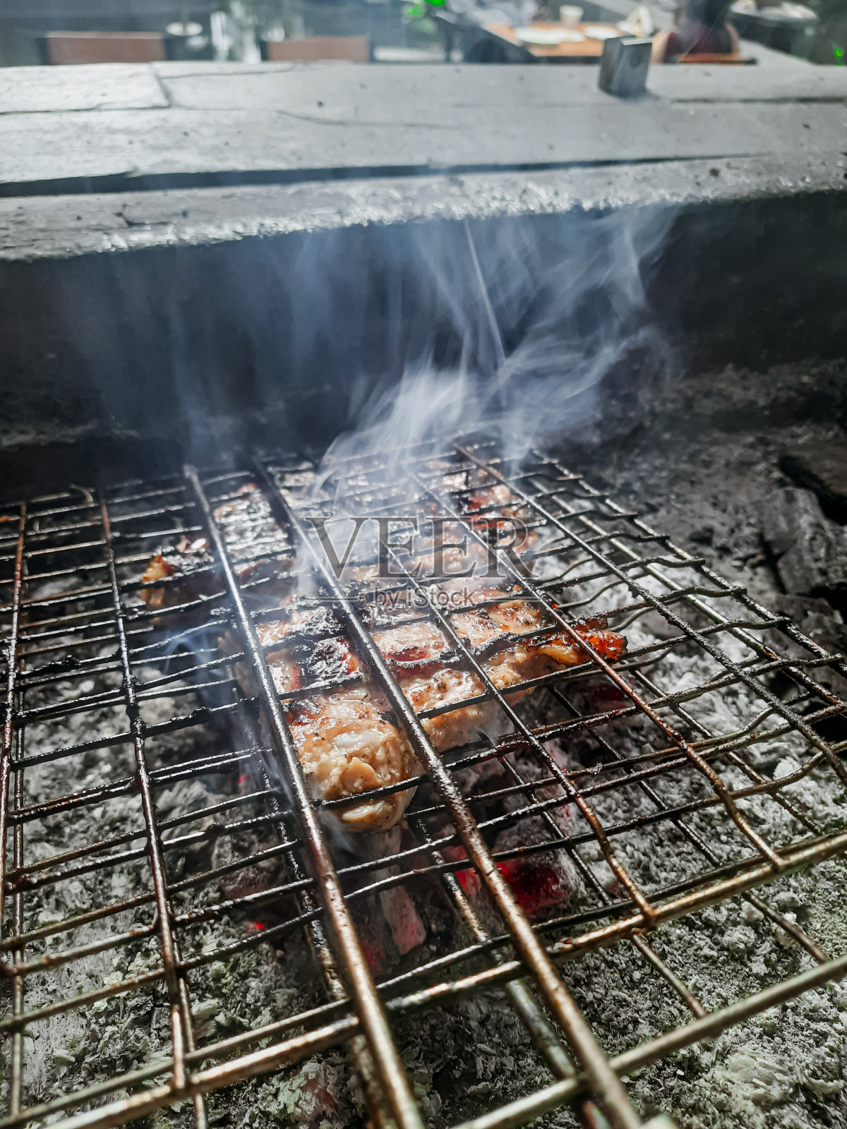 美味的烤肉架上的烟雾和火焰。烤肉串在燃烧的烤架上把肉串和蔬菜串在一起。照片摄影图片