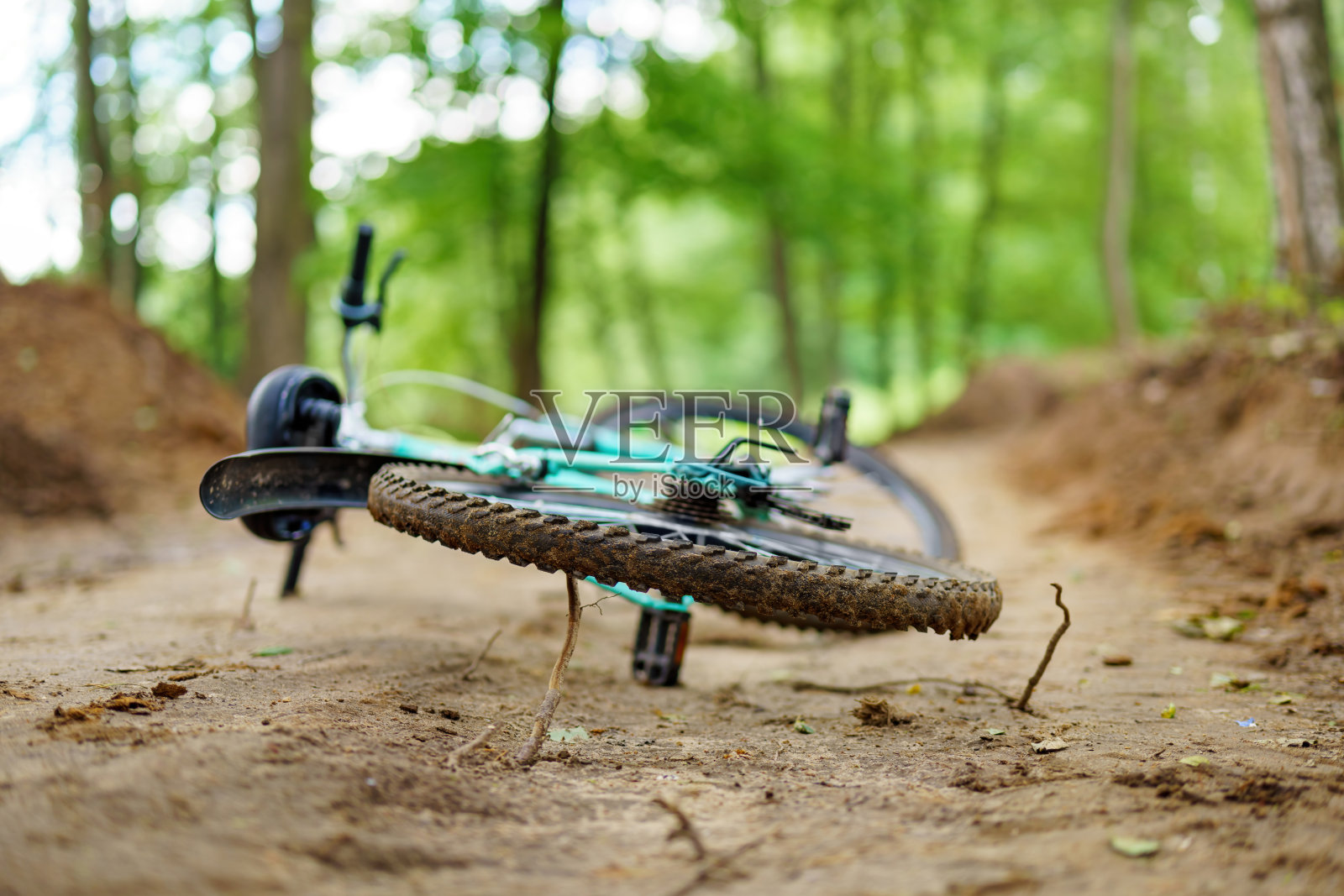 自行车被遗弃在泥泞的森林小路上，人类活动与自然并存照片摄影图片