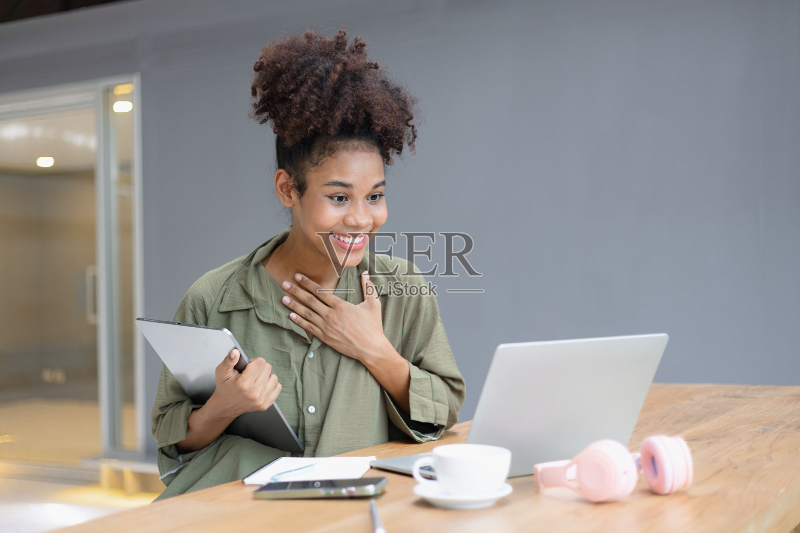 非裔美国女性自由职业者使用平板电脑和笔记本电脑在办公桌上工作。照片摄影图片