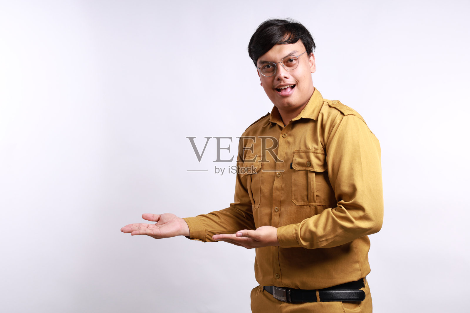 快乐的印尼政府雇员站着，在空白的地方侧身展示照片摄影图片