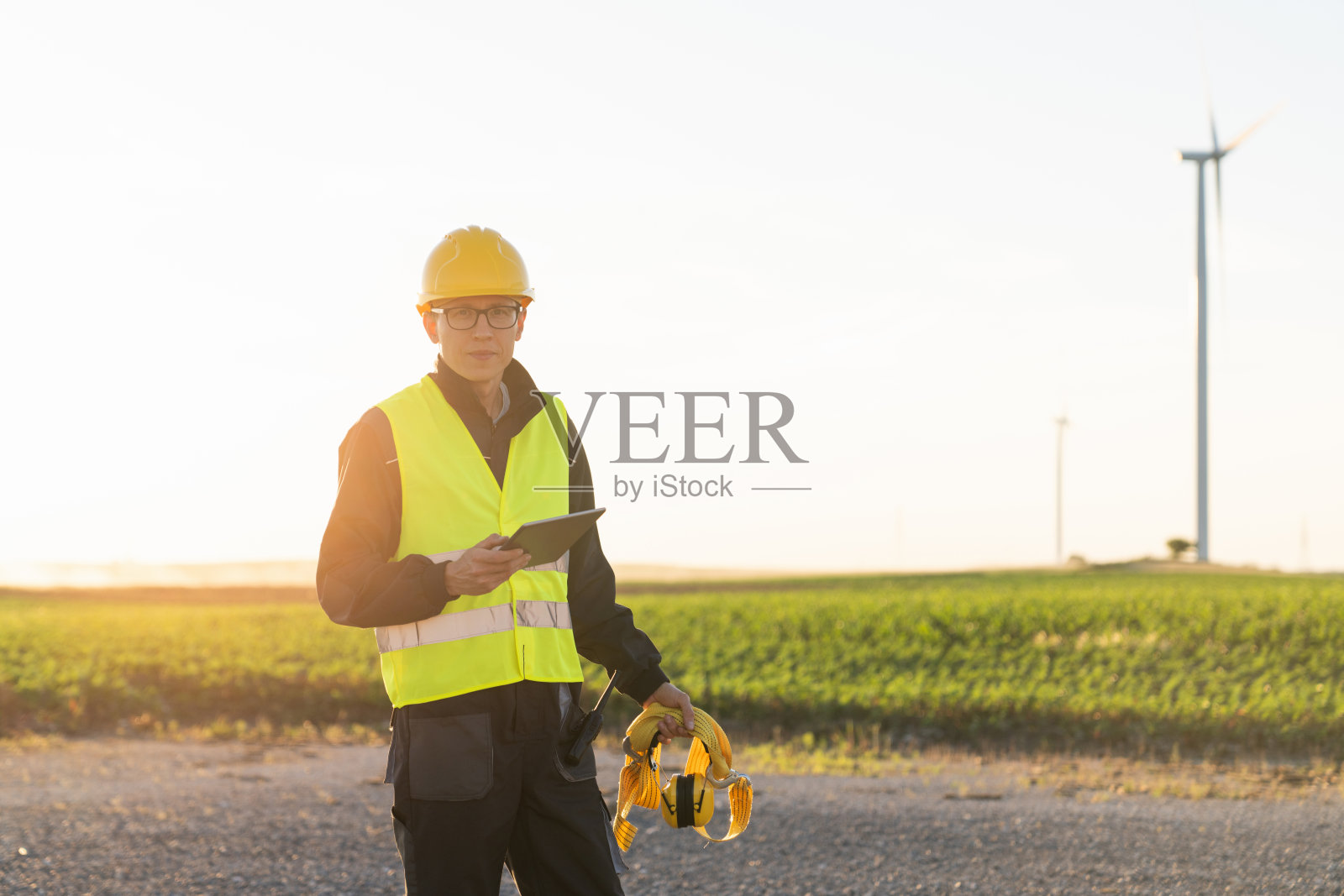 拿着数码平板电脑的工程师在风力涡轮机现场工作照片摄影图片