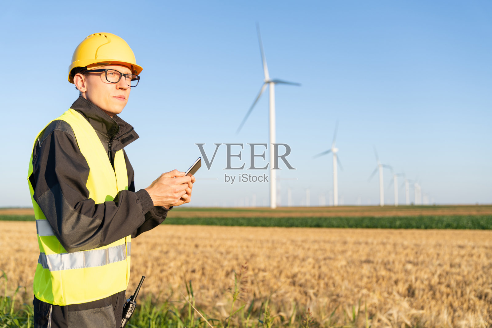 拿着数码平板电脑的工程师在风力涡轮机现场工作照片摄影图片