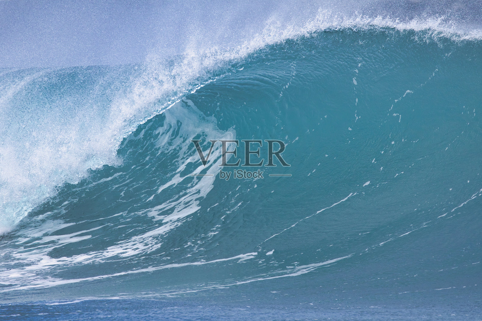 仰望着一个巨大而高耸的海浪。照片摄影图片