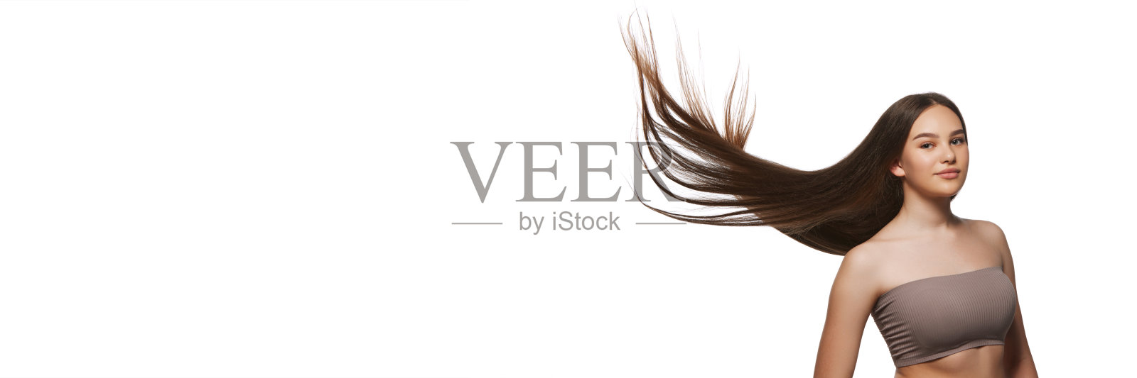 美丽的年轻女孩，长而有光泽的棕色直发，在白色的背景上孤立地摆姿势照片摄影图片