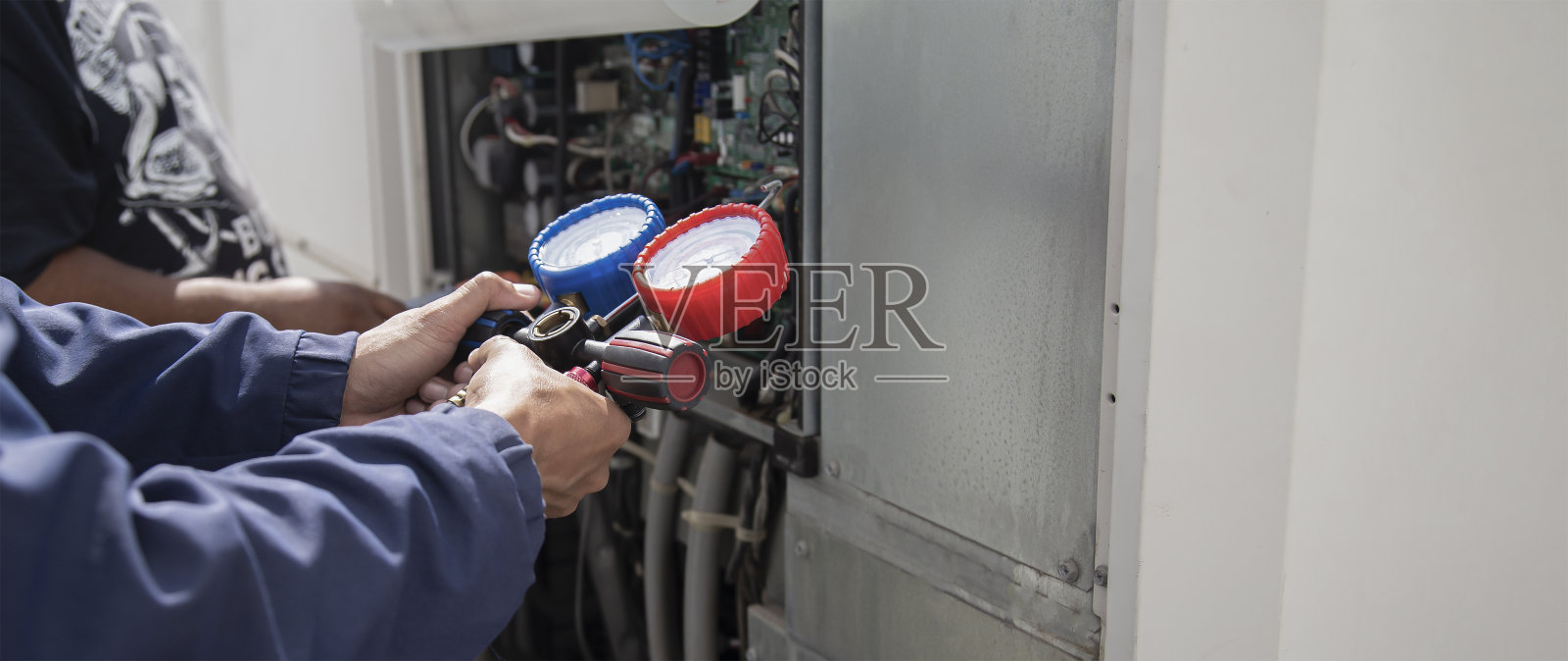 空调，暖通空调维修技术员使用仪表检查制冷剂并添加制冷剂。照片摄影图片