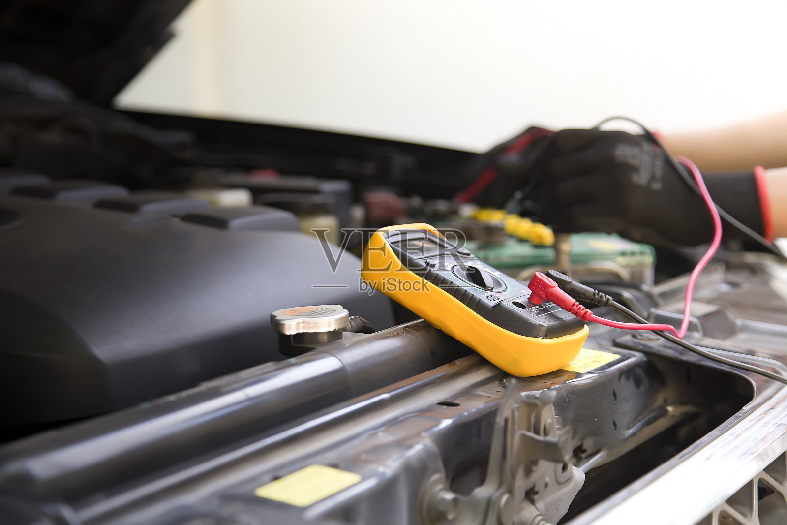 汽车修理工检查电池，修理和更换发动机部件。照片摄影图片
