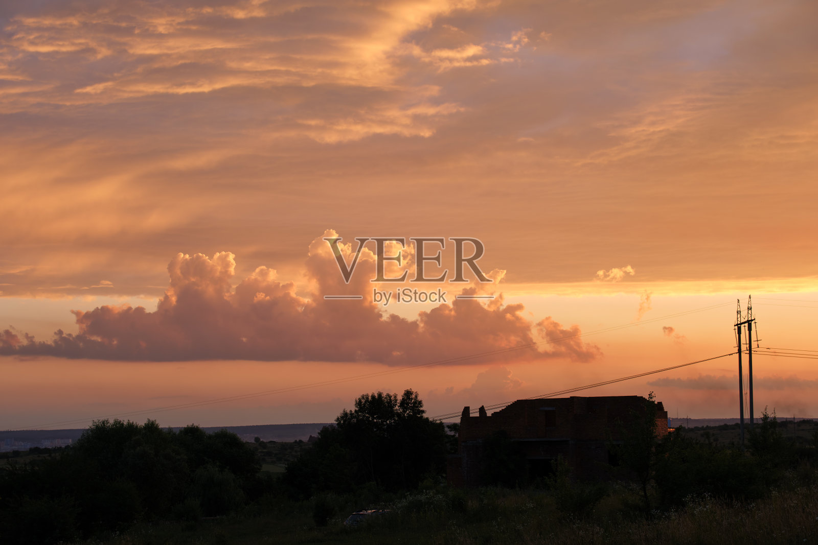 日出时高压塔和电线的黑暗剪影。照片摄影图片