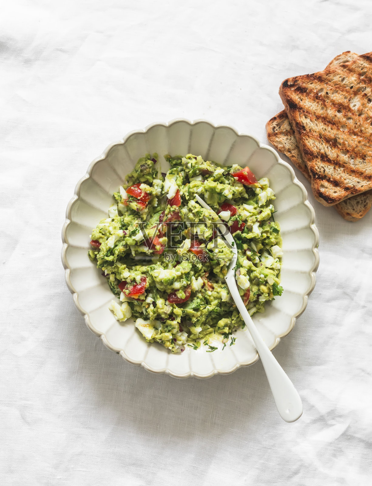 牛油果，鸡蛋，红洋葱，圣女果，绿色烤面包片和烤全麦面包在浅色背景，俯视图照片摄影图片