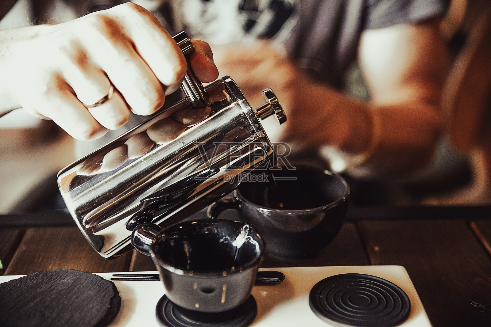 一个男人把茶倒进杯子里照片摄影图片