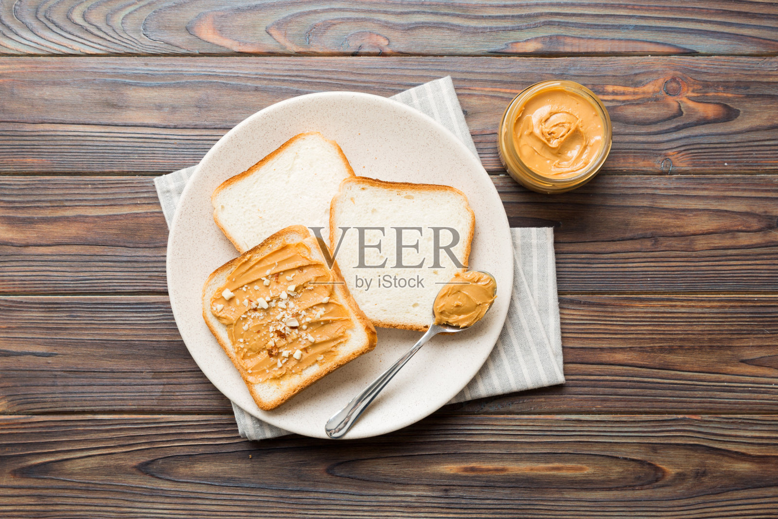 在浅色的桌子背景上放花生酱三明治或烤面包片。素食。美国美食的顶部视图与复制空间照片摄影图片