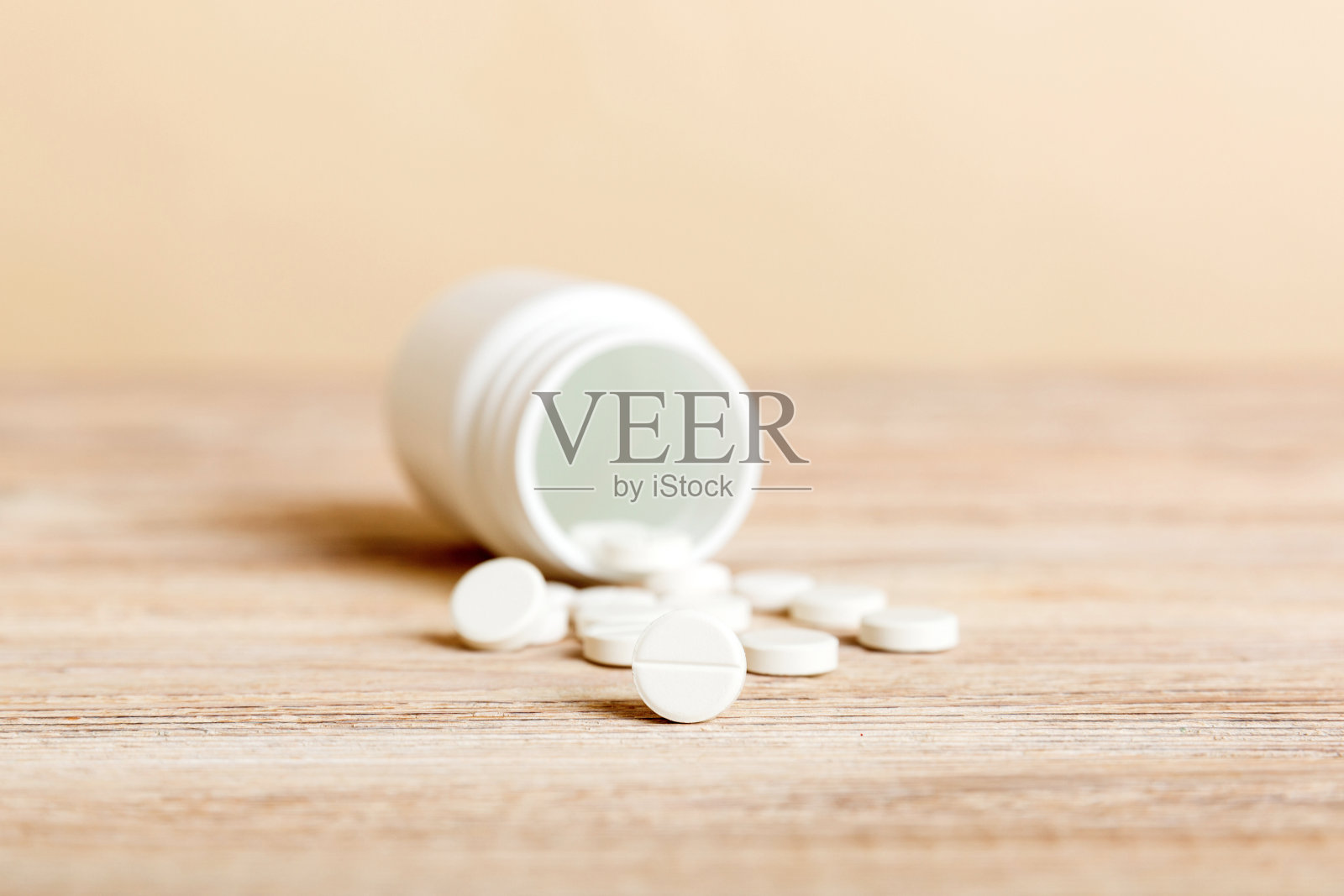 药瓶和白色药片散落在浅色的背景上。药品和处方药平铺背景。白色药片和药片从药瓶中溢出照片摄影图片