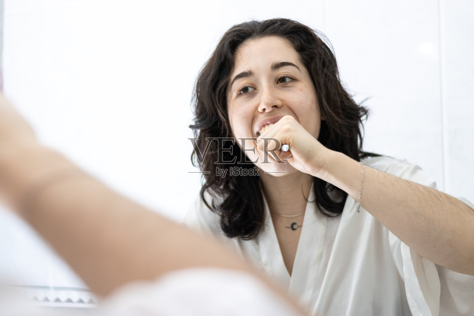 一个年轻的拉丁女孩在家里的浴室刷牙的画像。保持口腔卫生习惯对我们的健康非常重要。照片摄影图片