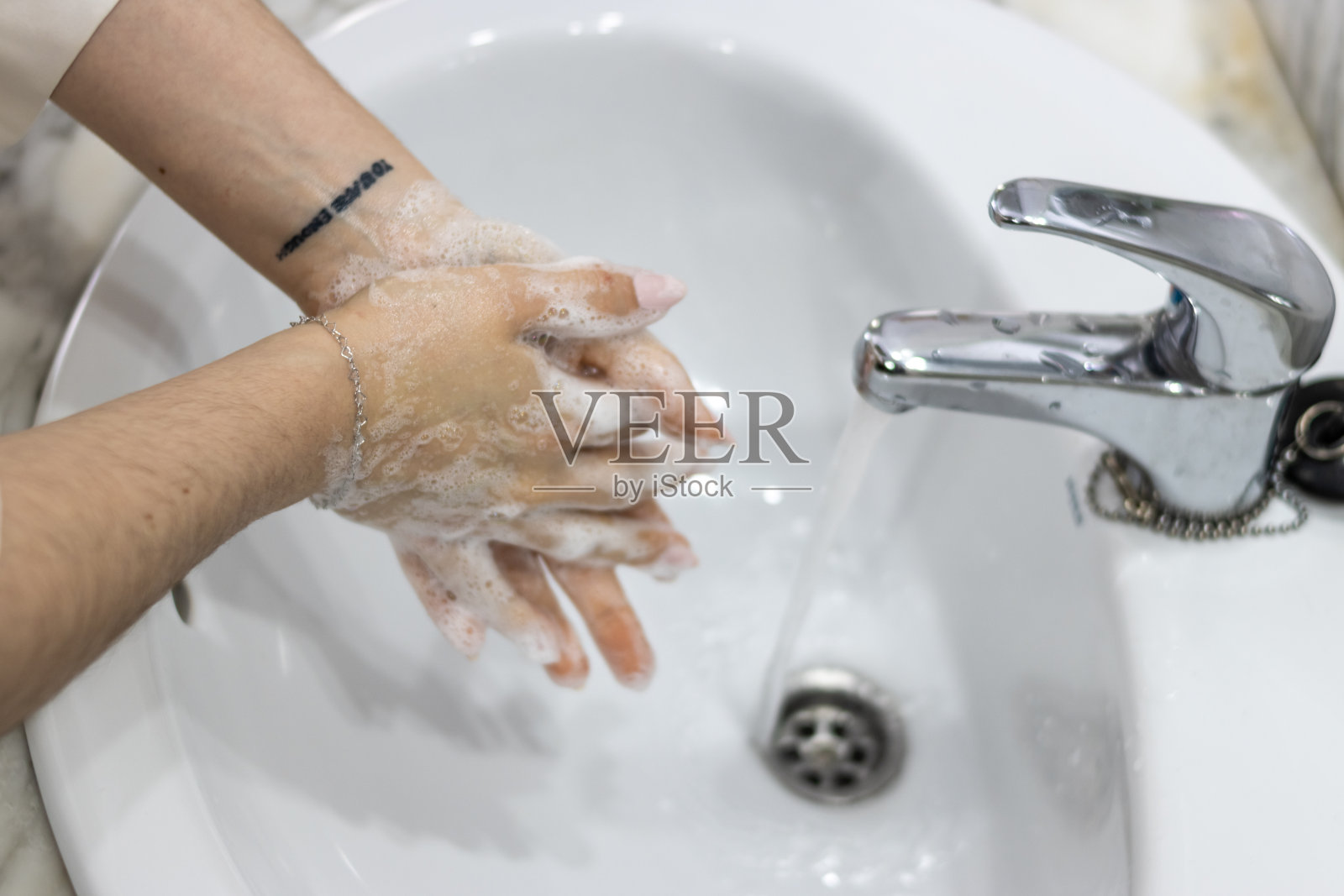 卫生的手。一个面目全非的女人在浴室洗手。照片摄影图片