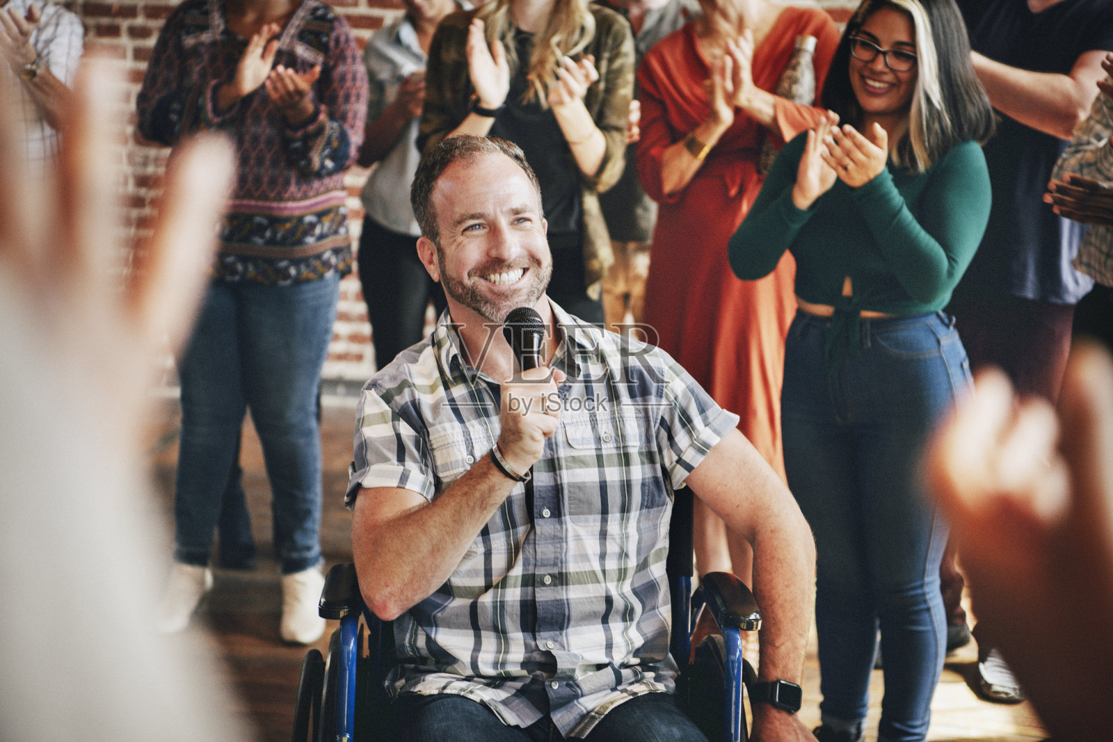 一个残疾人在车间里对着麦克风讲话照片摄影图片