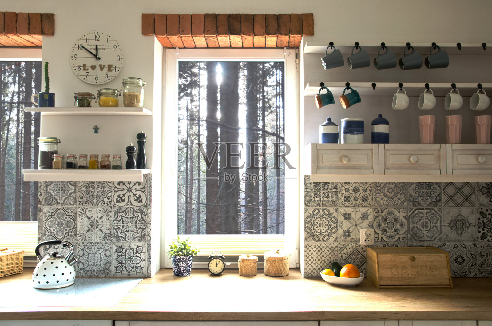 舒适的室内厨房在斯堪的纳维亚风格的小屋与窗户砖和森林景观。木制家具及设计装饰。照片摄影图片