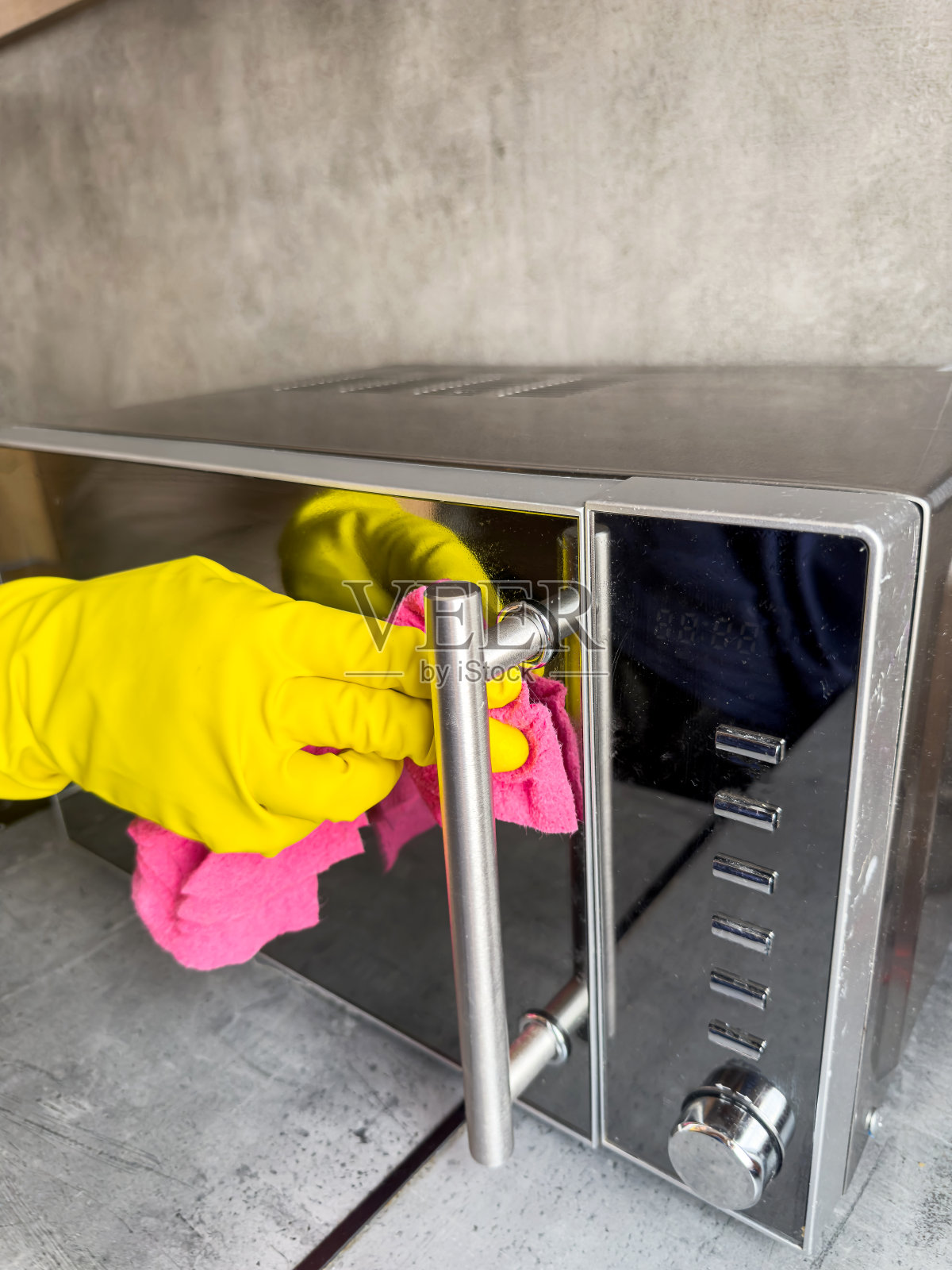 戴着手套的女性双手用抹布清洁服务擦拭现代厨房的木制台面照片摄影图片