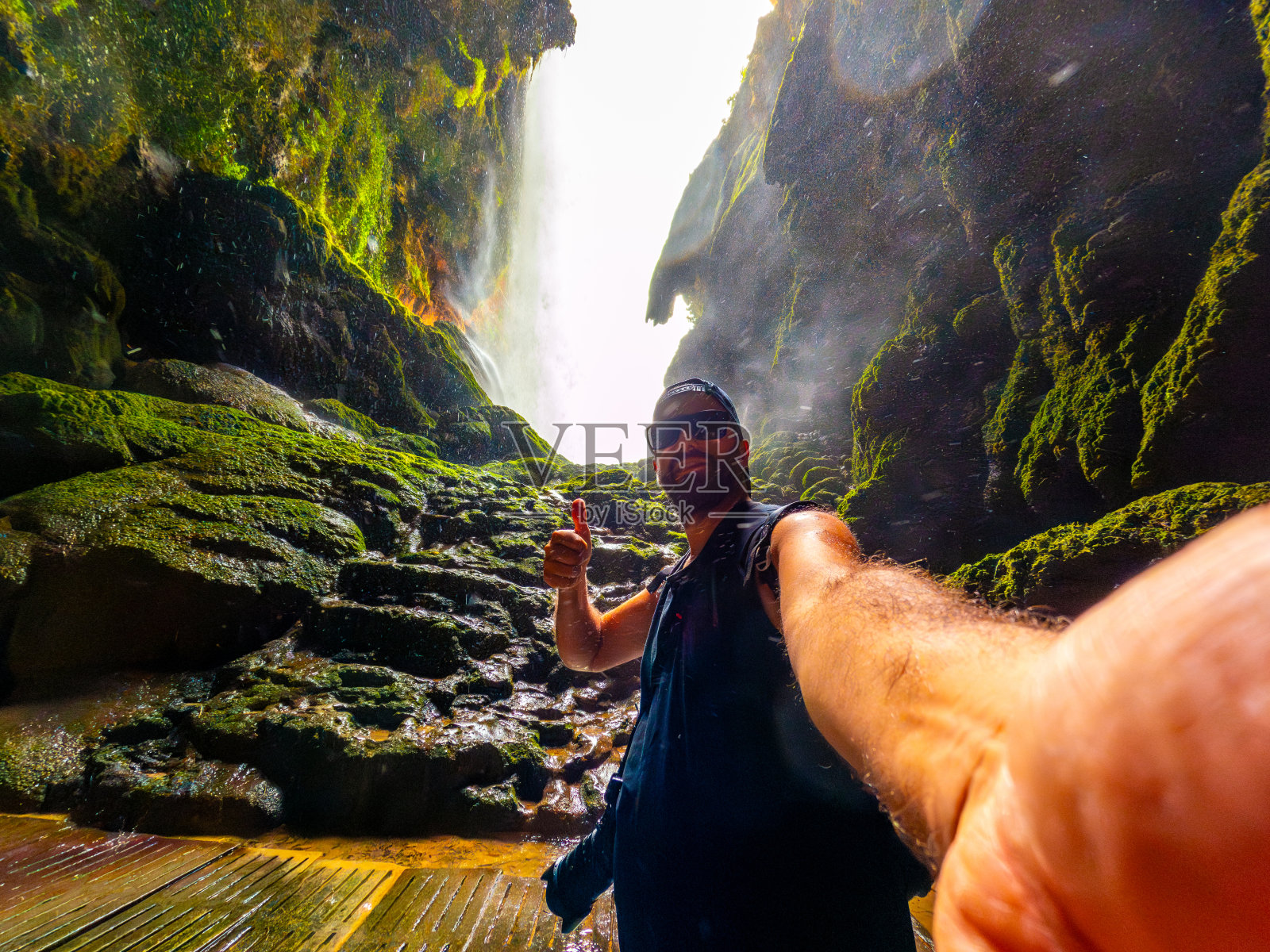 在阿拉贡的Monasterio de Piedra自然公园，一名游客在Cola de Caballo瀑布的虹膜洞内照片摄影图片