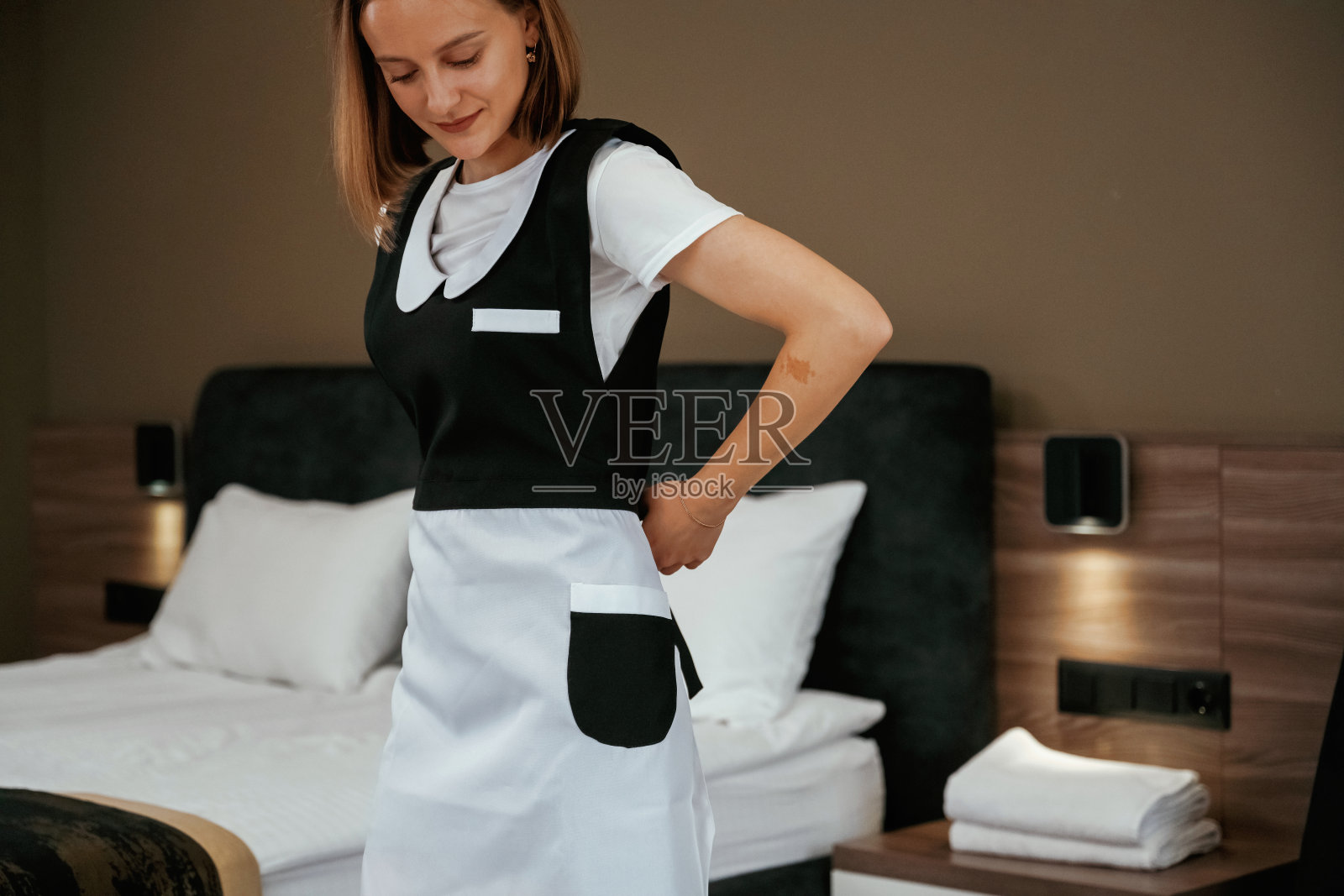 豪华的房间。年轻的女服务员在旅馆里照片摄影图片