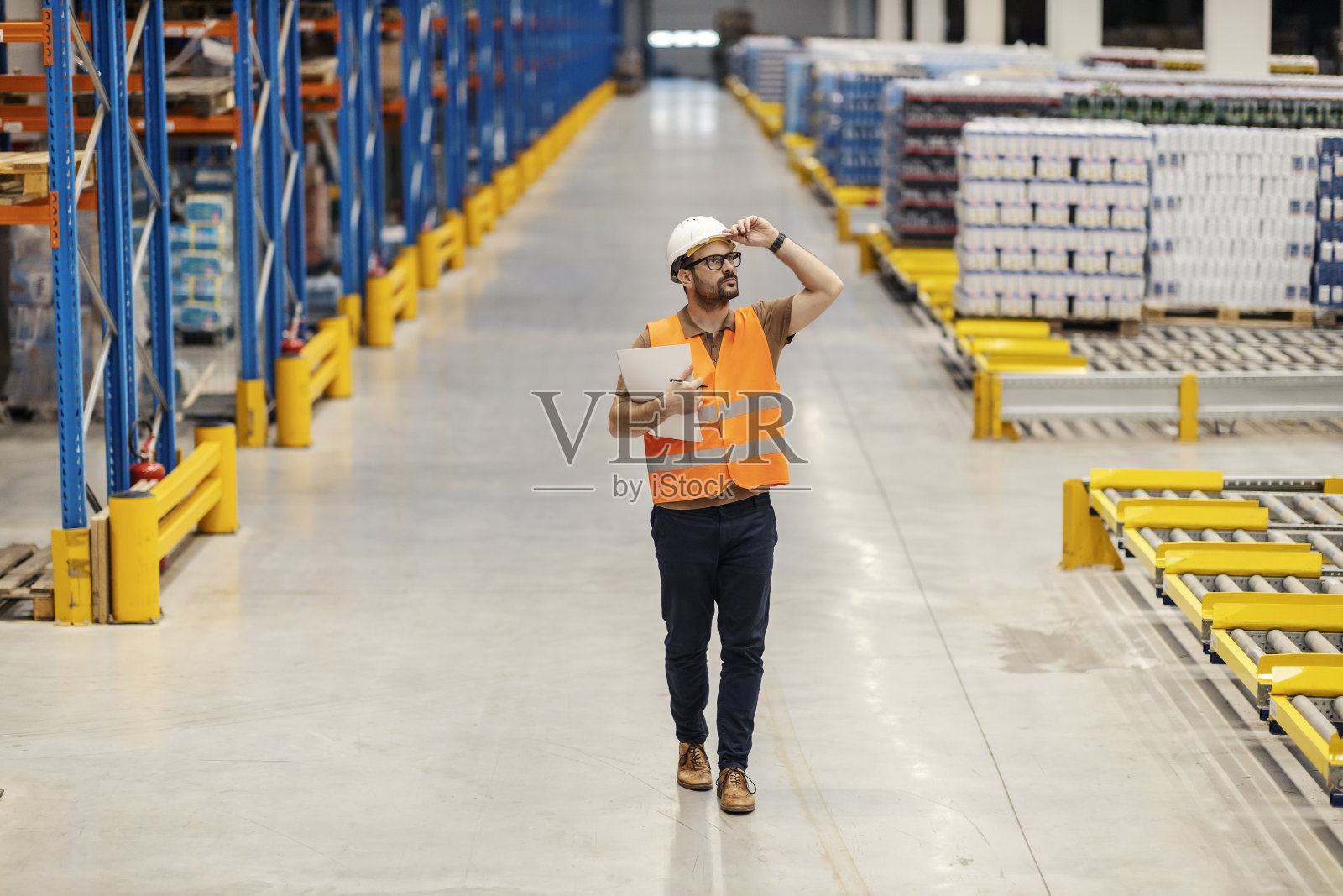 仓库经理正在巡视设备并检查仓库的商品储备情况。照片摄影图片
