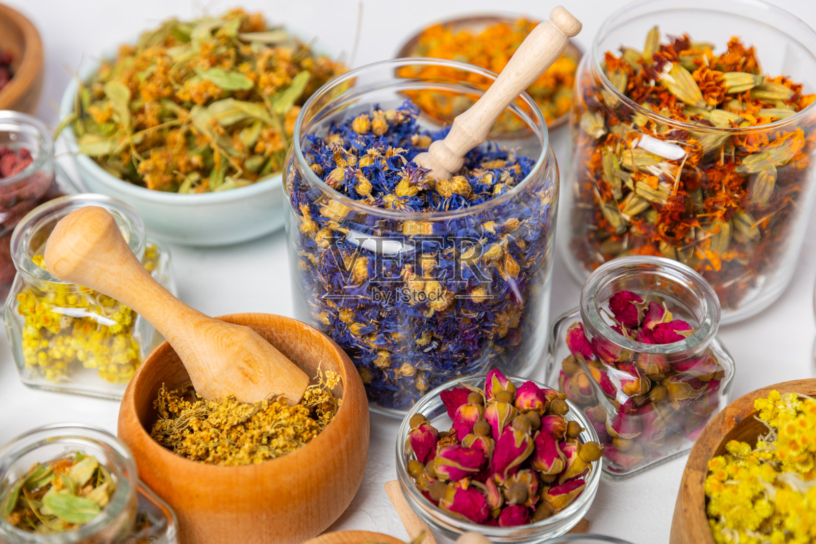 木质背景上的干草本和浆果茶。茶党概念。草药。治疗药草。替代医学。菩提树，金盏花，矢车菊，万寿菊，三色菊，茶玫瑰。照片摄影图片