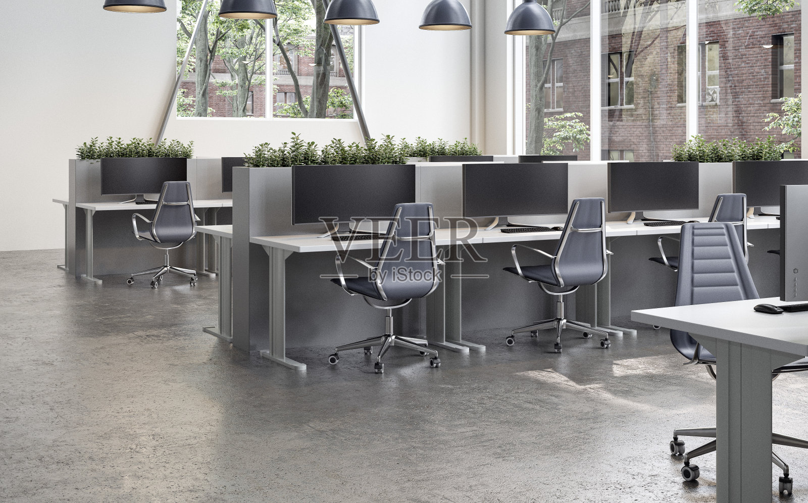 现代办公室内部，在早晨的阳光下，有办公桌和水泥地上的大窗户照片摄影图片