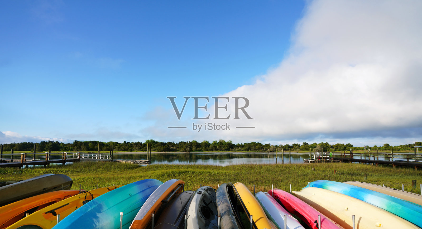 在北卡罗来纳州波弗特的海岸上，五颜六色的皮划艇排着队，远处是泰勒溪和胡萝卜岛照片摄影图片