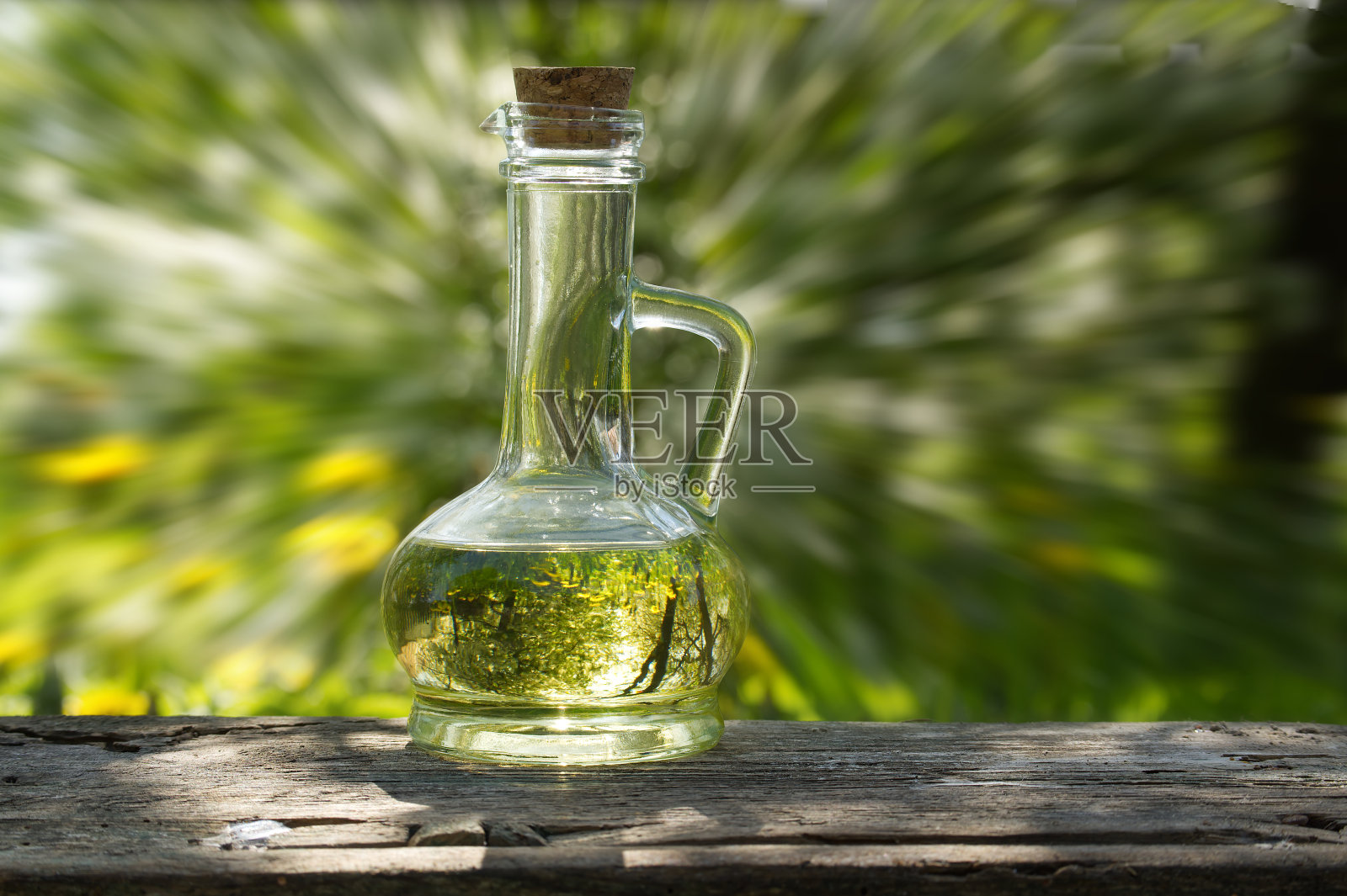 在模糊的绿草背景上装满油的罐子照片摄影图片