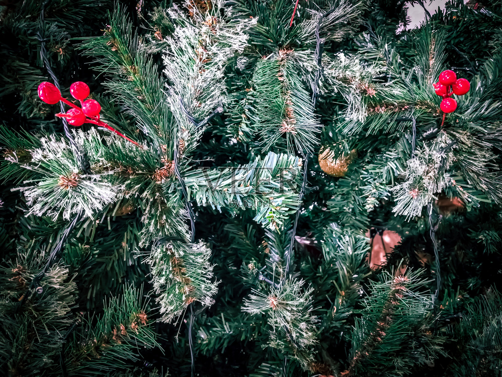圣诞树上挂着红色的浆果和雪花。圣诞节的背景照片摄影图片