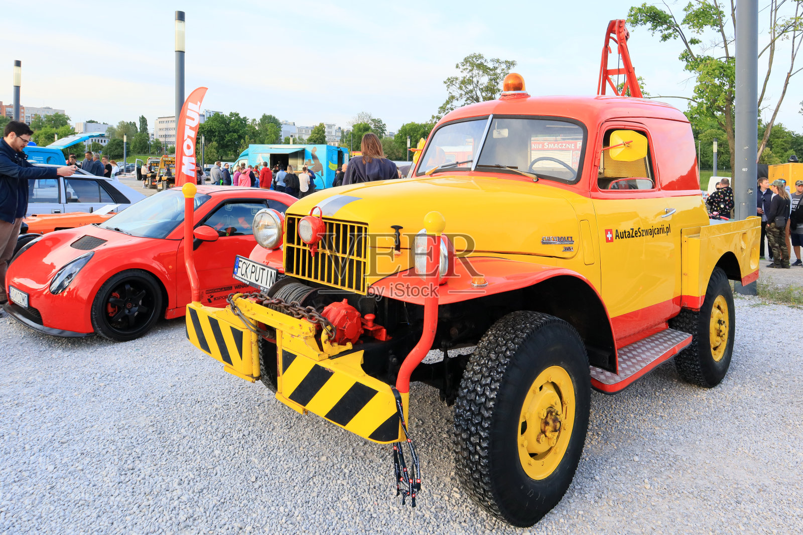 一辆红黄相间的经典雪佛兰3800在华沙的复古汽车大会上亮相照片摄影图片