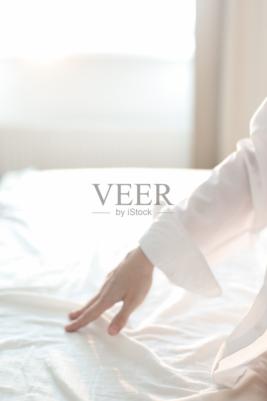 把手放在柔软的羽绒被上。女人摸床单，特写。年轻女子在床上的亲密。柔软，温柔，温柔舒适的早晨概念照片摄影图片