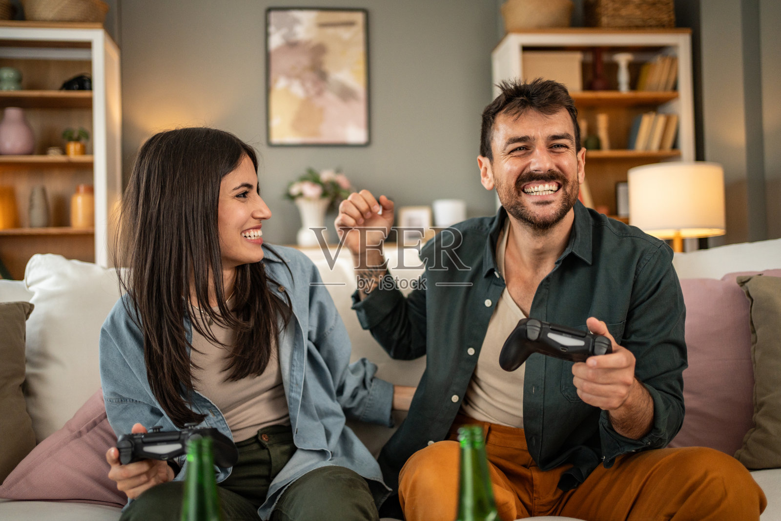 一对相爱的年轻情侣在家里一起玩电子游戏照片摄影图片