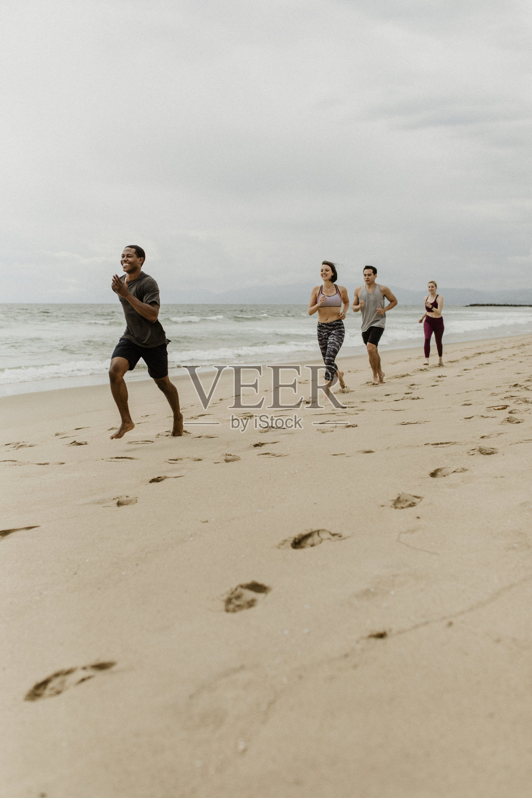 快乐的朋友一起在沙滩上慢跑照片摄影图片
