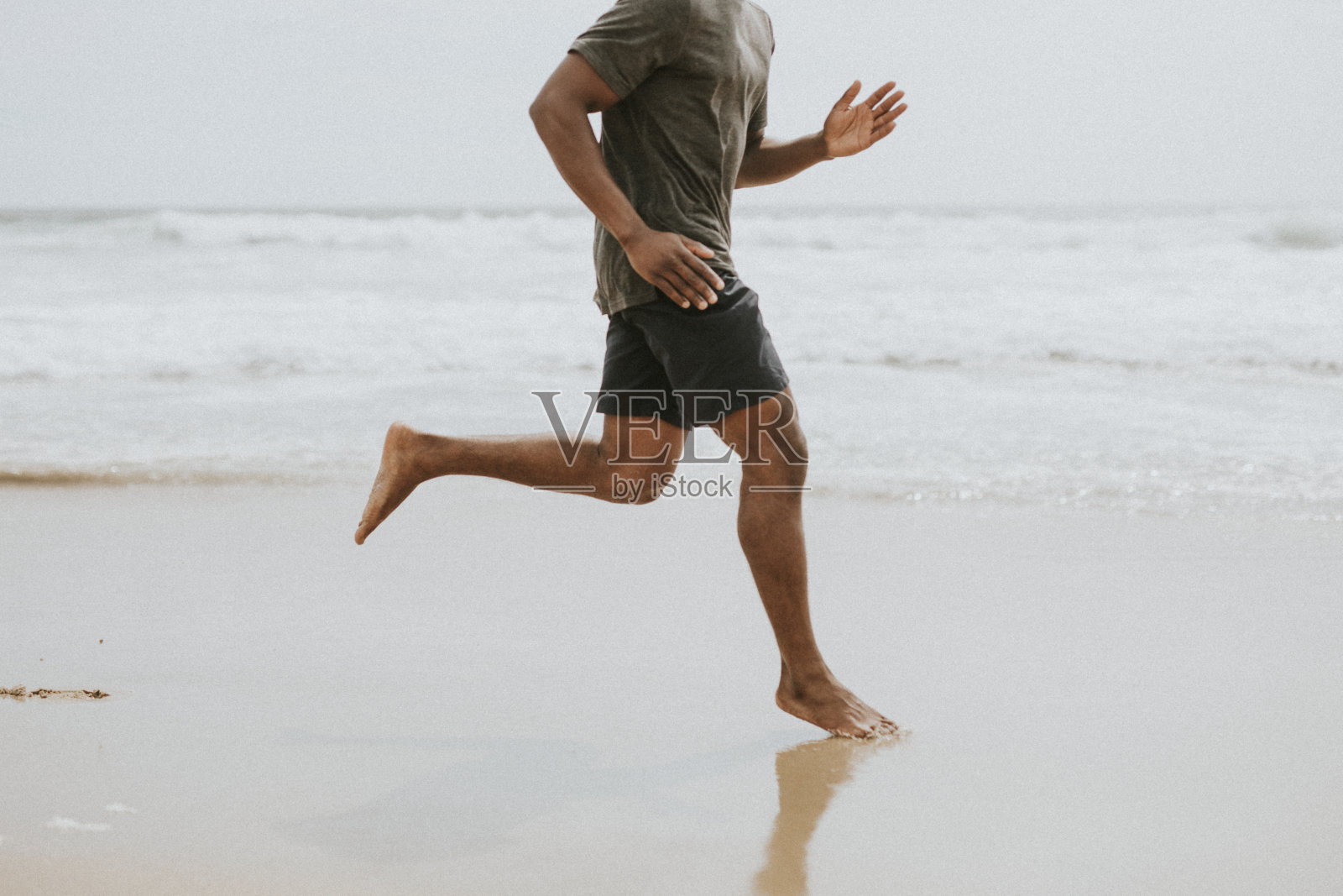 一个黑人在沙滩上奔跑照片摄影图片