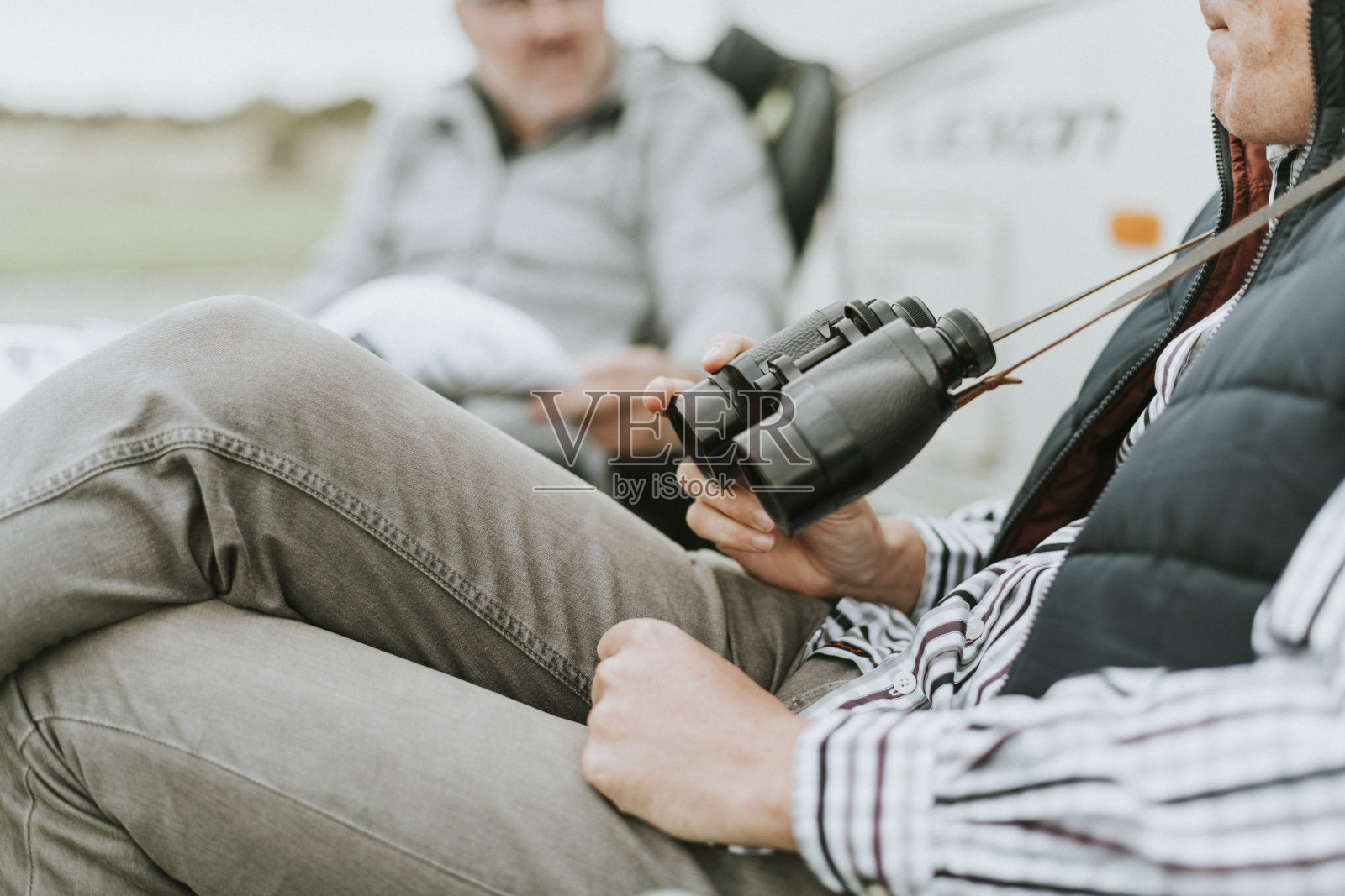脖子上挂着望远镜的老人照片摄影图片