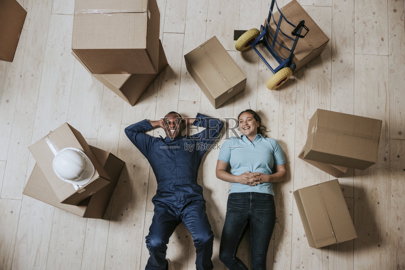 快乐的搬家服务人员躺在地板上照片摄影图片