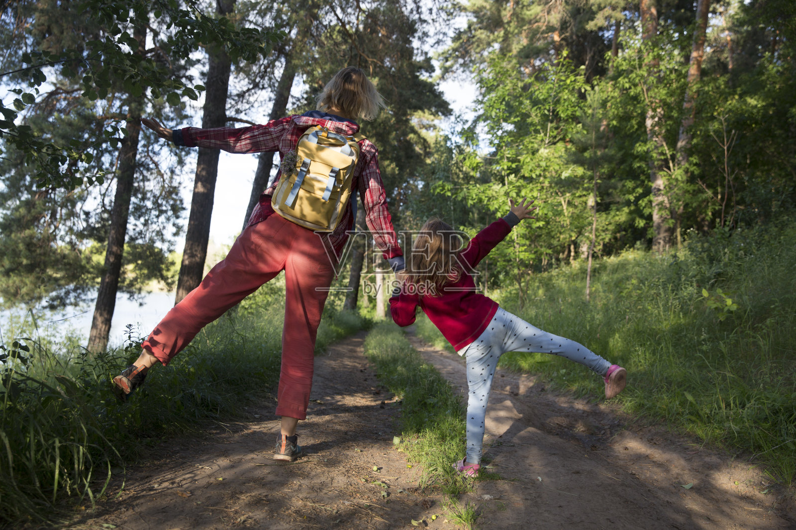妈妈和孩子女儿背着双肩包走在森林里。居家度假，超本地旅游，家庭出游，度假，自然环境。友好家庭的概念。照片摄影图片
