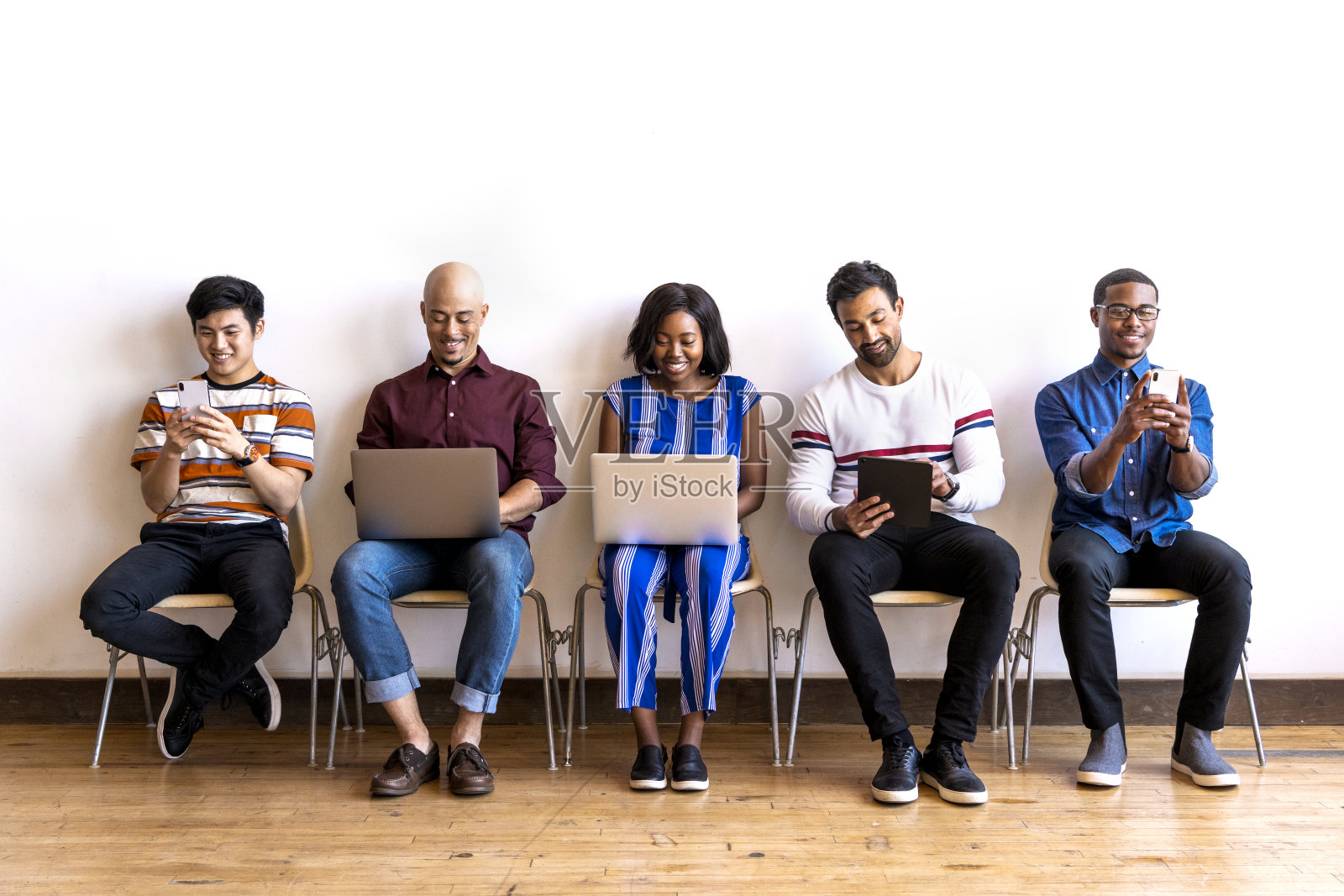 同事们坐在一排使用电子设备照片摄影图片