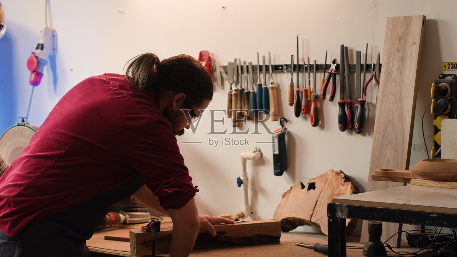 细木工的工匠用钳子夹住一块木头照片摄影图片