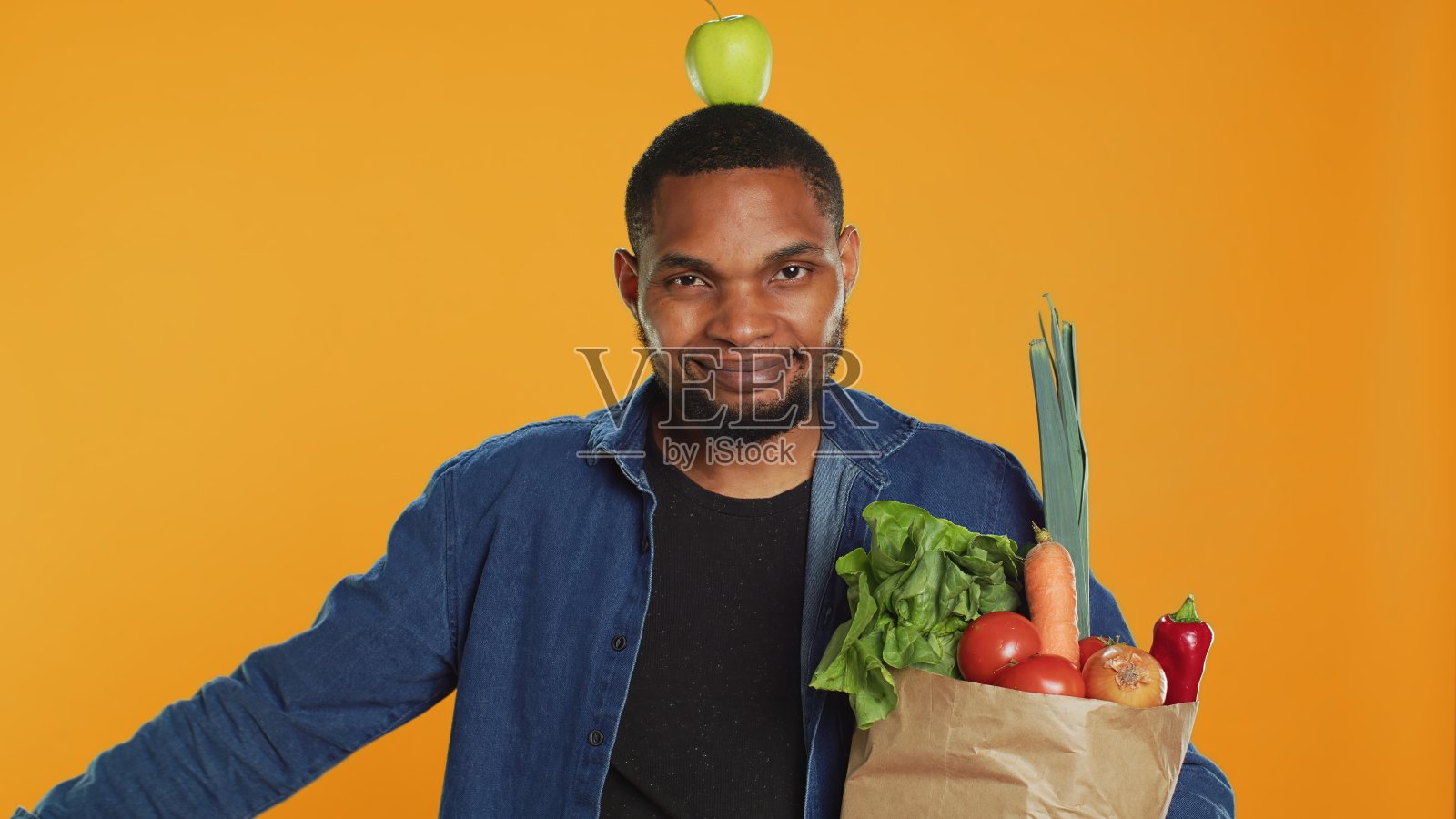 顽皮的素食主义者头上顶着苹果跳舞照片摄影图片