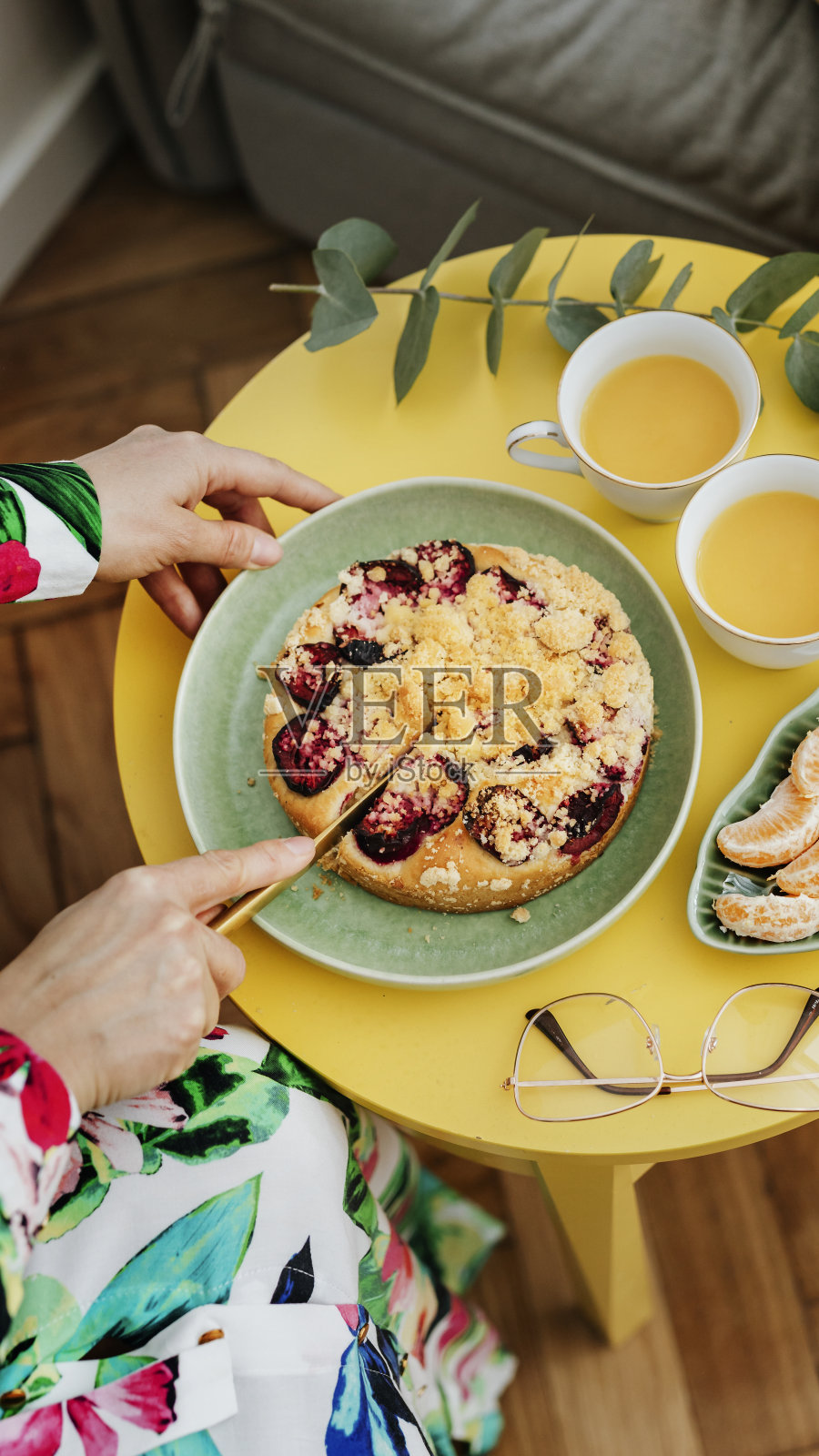 女人正在切一片李子酥派照片摄影图片