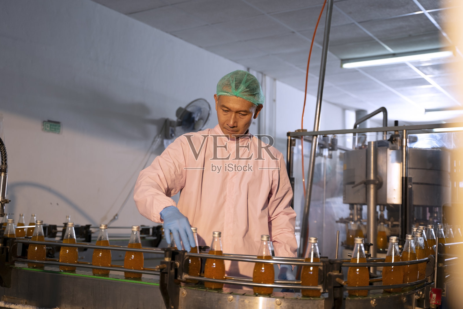 员工在饮料厂工作。照片摄影图片