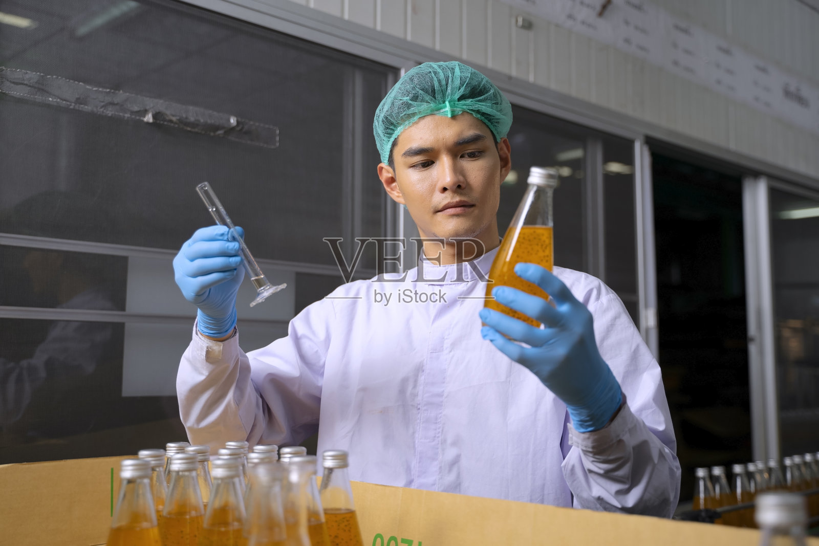 员工在饮料厂工作。照片摄影图片